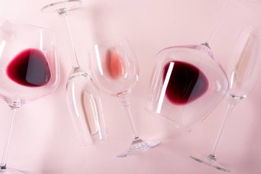 Pembe arka planda kırmızı, gül ve beyaz şarap ile çeşitli şarap kadehleri. Şarap degustation kavramı. Düz yatıyordu. Üst te. Kopyalama alanı