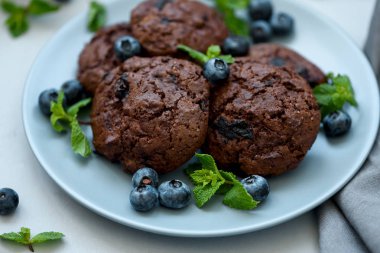 Çikolata cips ve yaban mersini gri ahşap arka planda çikolata kurabiye. Yaz yemeği. Yumuşak odaklama.
