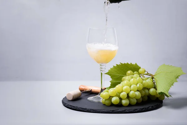 白ワイン シャンパン をボトルからグレーの背景にワイングラスに注ぎます ホリデーのお祝いのコンセプト — ストック写真