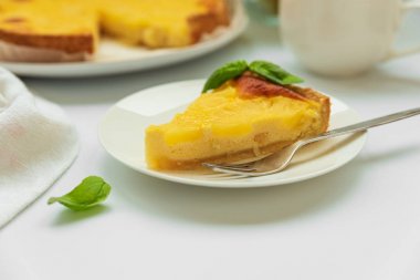 Beyaz masada çay fincan ı ile yeşil yaprakları süslenmiş baş aşağı ananas kek dilimlenmiş. Yaz tropikal tatlısı. Ön görüş. Kopyalama alanı