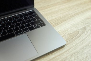 Ahşap masa üzerinde metalik dizüstü bilgisayar. Üst te. Ofis işyeri minimal kavramı
