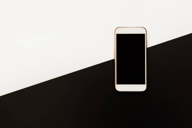 Beyaz ve siyah arka planda beyaz akıllı telefon. Kişisel aksesuarların üst görünümü.