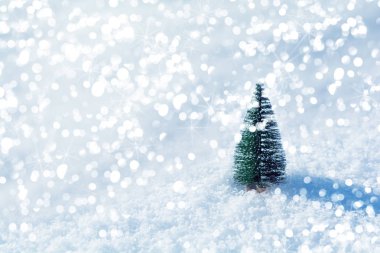 Kar arka planında ışıkları olan fidan ağacı oyuncağı. Noel ve Yeni Yıl bayramı kutlaması konsepti.