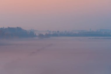Gün batımında renkli sisli sonbahar manzarası. Kırsal bölgede hava manzarası. Renkli sonbahar arkaplanı. Yumuşak odak