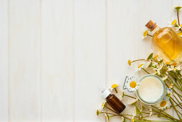 Kamille Bloemen Cosmetische Flessen Etherische Olie Extract Witte Houten Achtergrond — Stockfoto