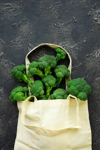 Beige grocery bag with green broccoli florets on black background