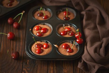 Çikolatalı kek pişiriyorum. Kahverengi ahşap arka planda taze böğürtlenli çiğ vejetaryen muzlu kek. Üst Manzara. Yaz yemeği