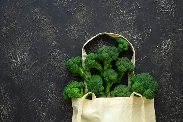 Beige grocery bag with green broccoli florets on black background