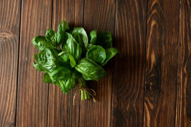 Kahverengi ahşap arka planda taze yeşil fesleğen. Üst Manzara. Düz yatıyordu