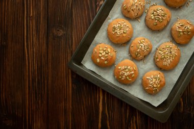 Kepekli, ayçiçekli ve kabak tohumlu taze ev yapımı çıtır ekmekli çörekler. Üst görünüm.