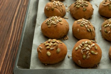 Kepekli, ayçiçekli ve kabak tohumlu taze ev yapımı çıtır ekmekli çörekler. Üst görünüm.