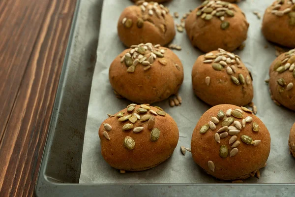 Kepekli, ayçiçekli ve kabak tohumlu taze ev yapımı çıtır ekmekli çörekler. Üst görünüm.