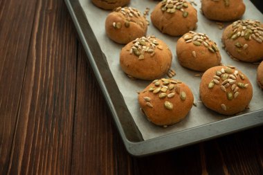 Kepekli, ayçiçekli ve kabak tohumlu taze ev yapımı çıtır ekmekli çörekler. Üst görünüm.