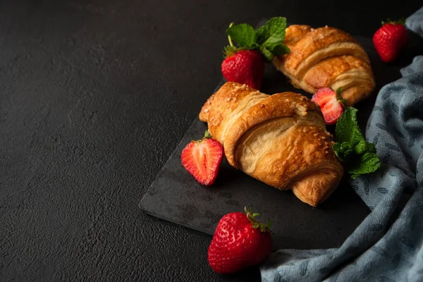 Färska Gyllene Croissanter Med Jordgubbar Mörk Skiffertavla Ovanifrån — Stockfoto