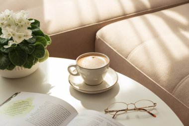 Kahve, kitap ve Afrika Menekşeli Konforlu Oturma Odası