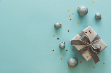 Açık Mavi Arkaplanda Noel süsleri olan Gümüş Hediye Kutusu