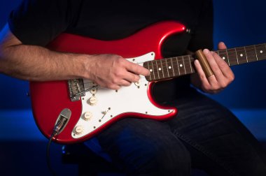 Kırmızı ve beyaz elektro gitar çalmak bir adam görünümü kadar yakın.