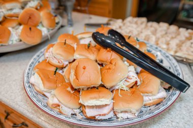 Hazır hindi sandviç sunumu için maşa ile bir plaka üzerinde yığılmış yığını.