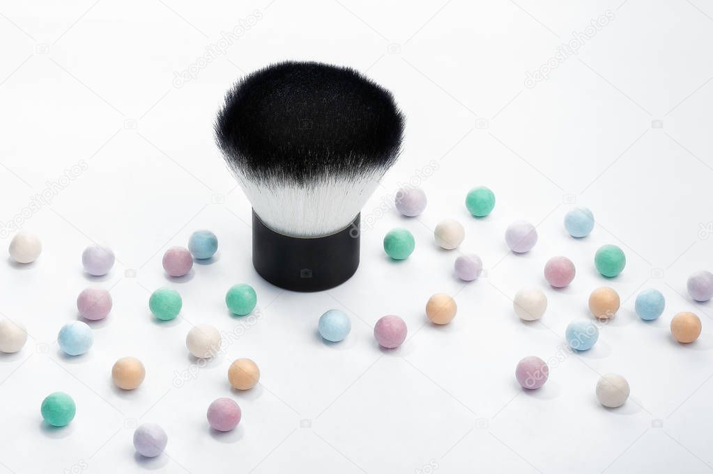 Mineral powder pearls spread out like confetti with kabuki makeup brush.
