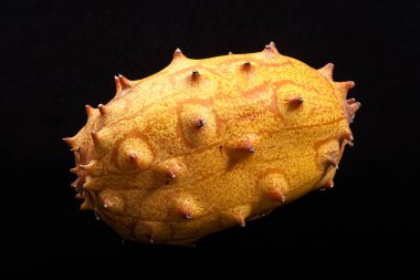 Siyah bir arka plan üzerinde izole kesilmemiş bir kiwano (boynuzlu kavun).