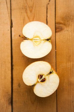 Ahşap arka planda iki elmanın yarısı