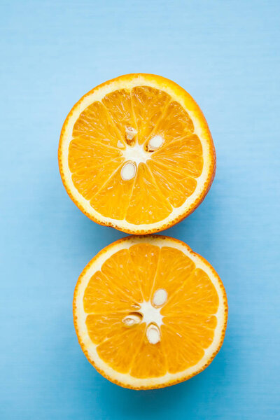 Two halves of orange on light blue background