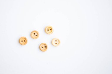 Beyaz arkaplanda küçük tahta düğmeler