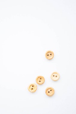 Beyaz arkaplanda küçük tahta düğmeler