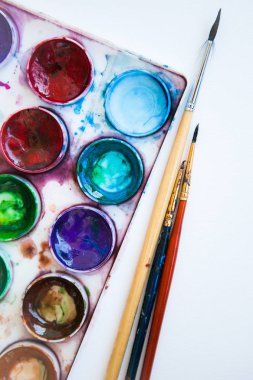 Su rengi boya (aquarelle) ve beyaz arka plan üzerinde fırçalar