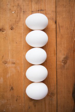 Ahşap arka planda beş beyaz yumurta