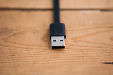 Ahşap arka planda siyah Usb kablosu