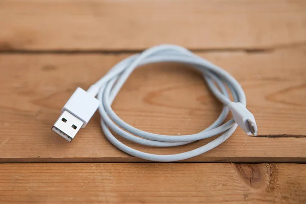 White USB cable on wooden background