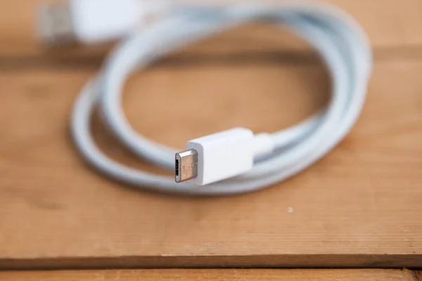 White USB cable on wooden background