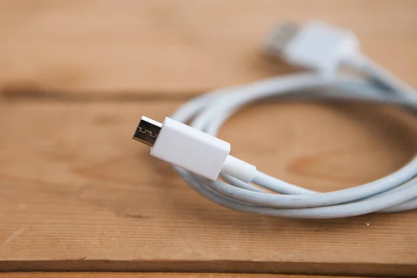 White USB cable on wooden background