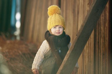 Çiftlikte sarı şapkalı küçük bir çocuk.