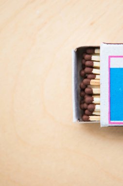 Ahşap arka plandaki kutunun üzerindeki kibritler