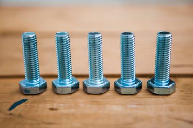 Ahşap arka planda bazı metal yazılar (kendi kendine tıkırdayan vidalar, cıvatalar)  