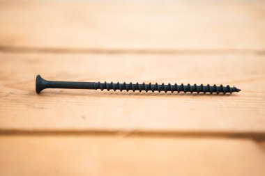 Ahşap arka plan üzerinde metal siyah çivi