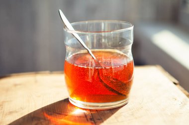 tahta masa üzerinde kaşık ile bal fincan