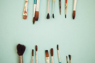 Açık mavi arka plandaki boya fırçaları kümesi