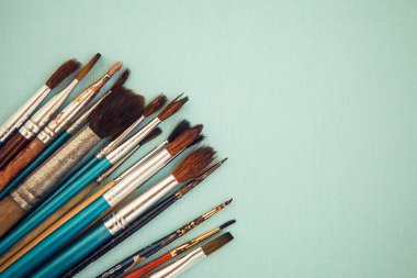 Açık mavi arka plandaki boya fırçaları kümesi