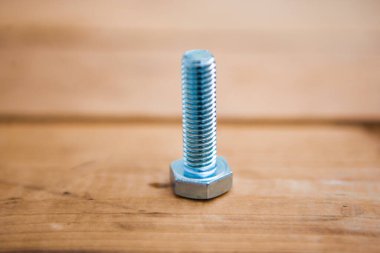 Bir metal cıvata, ahşap arka planda metal eşya.