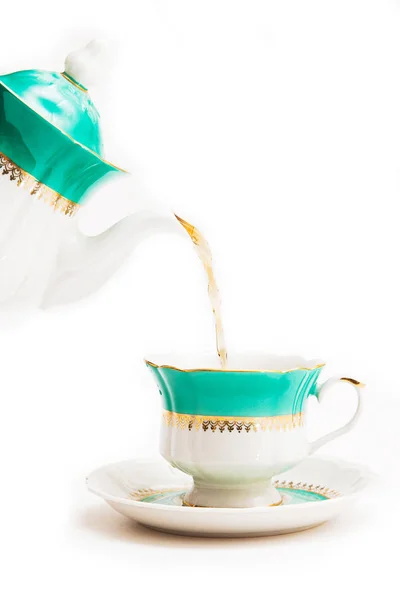 Green indian cup of tea and kettle on white background. Isolated on white. Indian dishes