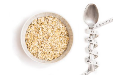 Yulaf ezmesi beyaz tabak, kaşık ve beyaz arka plan üzerinde santimetre. Beyaz izole