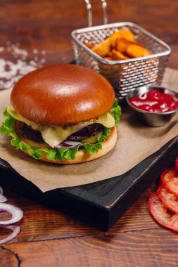 Restorandaki masada patates kızartmalı ve ketçaplı hamburger. Fast food, abur cubur