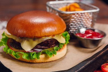 Restorandaki masada patates kızartmalı ve ketçaplı hamburger. Fast food, abur cubur