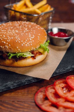 Restorandaki masada patates kızartmalı ve ketçaplı hamburger. Fast food, abur cubur