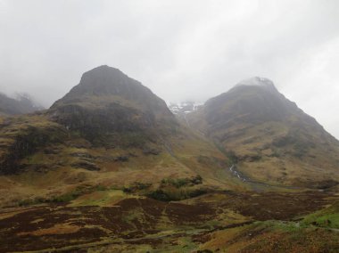 Yeşil yatay, tepeler, dağlar, kayalar ve ağaçlar..