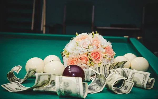 very beautiful flowers and money on a pool table with balls