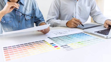 Takım çizim ve rötuş meslektaşım grafik tasarımcı grafik tablet üzerinde görüntü ve renk renk örneği örnekleri dizüstü bilgisayar üzerinde seçim için seçin.